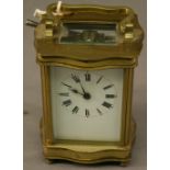 A FRENCH BRASS FIVE-GLASS CARRIAGE CLOCK  of serpentine form, with shaped swing carrying handle, the
