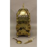 A BRASS LANTERN CLOCK by George Falconer & Co Ltd, Hong Kong, of traditional form with arched