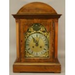 AN EDWARDIAN MAHOGANY BRACKET CLOCK having an arched top and glazed door,  the silvered chapter ring