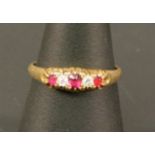 AN 18CT GOLD RUBY AND DIAMOND RING with three round-cut rubies interspersed by two conforming