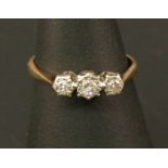 A 9CT GOLD PLATINUM SET DIAMOND THREE STONE RING having three illusion-set round-cut diamonds