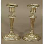 A NEAR PAIR OF EDWARDIAN SILVER CANDLESTICKS with fluted and reeded decoration in the Neo