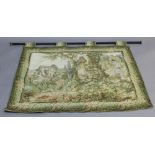 A MACHINE EMBROIDERED TAPESTRY WALL HANGING depicting a garden scene with watermill, turned pole