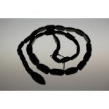 A 19TH WHITBY JET NECKLACE of serpent form having 34 segments. CONDITION: Good overall, re-stringing