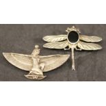 AN ART DECO WHITE METAL BROOCH of Egyptian revival form depicting a winged goddess in kneeling