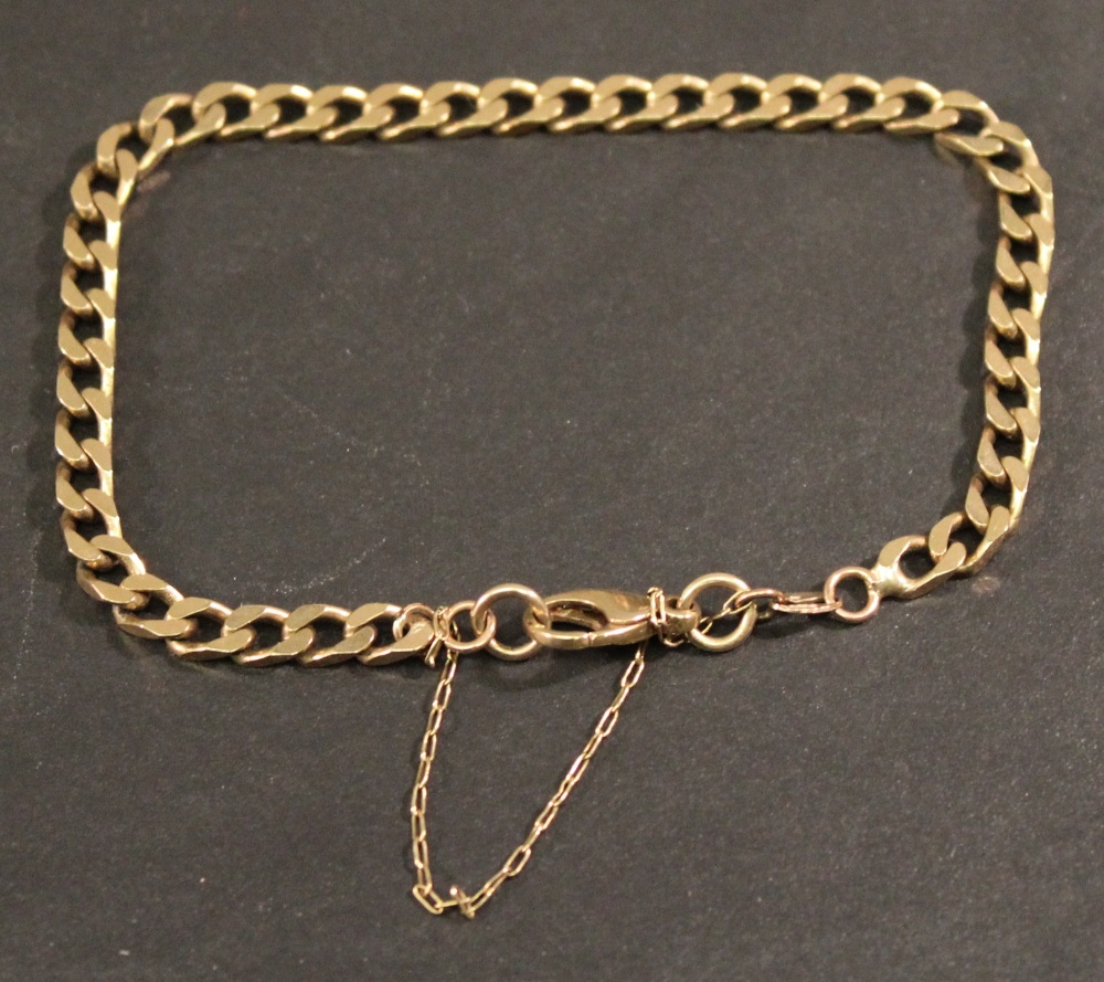 A 9CT GOLD CURB-LINK BRACELET with dog clasp and safety chain, marked 375. 18cm(L) 9grams