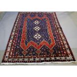 A PERSIAN SHIRAZ YALAMEH TYPE RUG having three central lozenges within a shaped floret filled