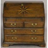 AN 18TH CENTURY OAK BUREAU of traditional form, the fall-front with inlaid star or sunburst motif,