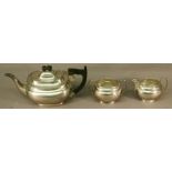 A NEAR MATCHING SILVER THREE PIECE TEASET comprising a teapot, sugar and cream , each of oval