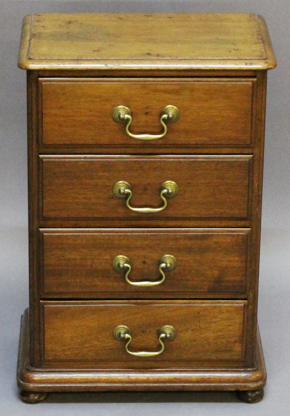 A SMALL EARLY 20TH CENTURY MAHOGANY CHEST OF DRAWERS having a moulded top, four moulded drawers,