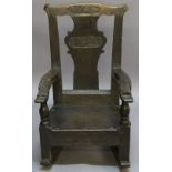 AN EARLY OAK CHILD'S ROCKING CHAIR having a yoke-form top-rail, shaped splat carved with initials