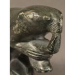 AN INUIT SOAPSTONE CARVING of an otter eating a fish, marked to base "Nonya, 1/24395 C. 14cm9h)