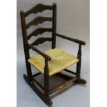 A 19TH CENTURY CHILD'S LADDER-BACK ROCKING CHAIR having four shaped horizontal splats between the