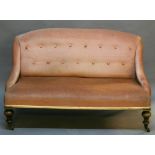 A VICTORIAN SALON SETTEE having a padded, buttoned, slightly humped back with short swept ends,