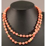 A CORAL NECKLACE of equal sized beads interspersed with gilt metal spacers. 81 beads. 92cm(L)