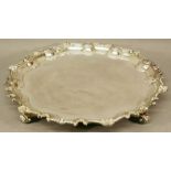 A LARGE SILVER SALVER of circular form with plain interior and moulded, shaped edge, raised on