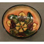 A MOORCROFT POTTERY BOWL of dished circular form, tube-lined with flowers and foliage against washed