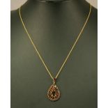 A 9CT GOLD GARNET-SET PENDANT and chain, the pendant of stepped tear-drop form set throughout with