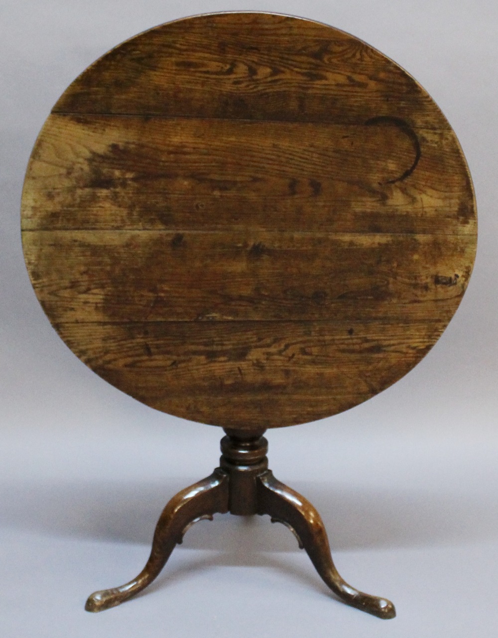 A GEORGIAN OAK SNAP-TOP STEM TABLE having a circular planked top, snap-top action and turned column,