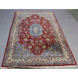 A TURKISH WOOL RUG with central foliate medallion in a floret filled ground and ornate spandrels, in