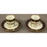 A PAIR OF EARLY 20TH CENTURY SILVER MOUNTED AYNSLEY COFFEE CANS AND SAUCERS decorated in white,