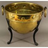 AN ARTS AND CRAFTS BRASS AND IRON PLANTER of dished circular form, with a moulded band of roundels