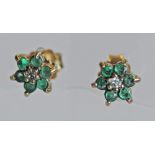 A PAIR OF YELLOW METAL EMERALD AND DIAMOND EARRINGS, a small central diamond with a band of