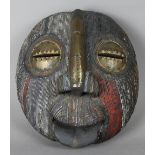 AN EARLY 20TH CENTURY GHANAIAN CARVED WOOD OVAL FACE MASK, with metal covered eyes and nose, applied