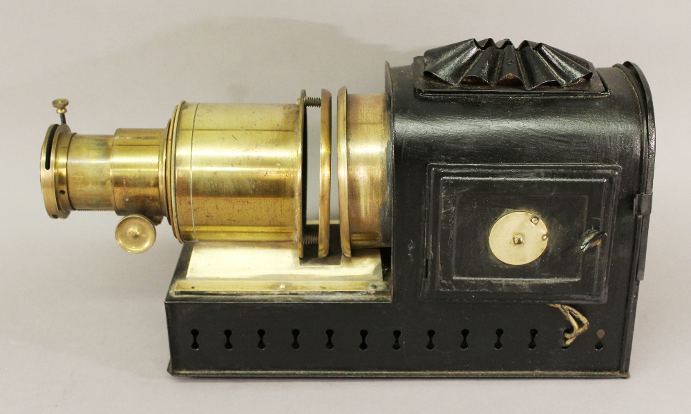 A LATE 19TH/EARLY 20TH CENTURY MAGIC LANTERN PROJECTOR with brass lens apparatus and tin body,