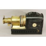 A LATE 19TH/EARLY 20TH CENTURY MAGIC LANTERN PROJECTOR with brass lens apparatus and tin body,