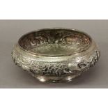 A 19TH/EARLY 20TH CENTURY BURMESE WHITE METAL BOWL embossed with a band of elephants, animals