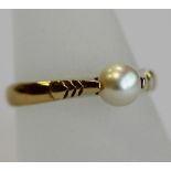 AN 18CT GOLD AND PEARL RING, the central pearl set in sloping shoulders with chevron designs, the