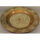 AN INDO-PERSIAN COPPER CHARGER of dished circular form, stamped with ornate foliate designs and