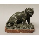 LATE 19TH / EARLY 20TH CENTURY DARK GREEN PATINATED BRONZE - SEATED TIGER on rocky outcrop, on red