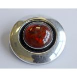 A DANISH 925S STERLING AND AMBER BROOCH by Niels Erik From, circular with central  amber cabochon,