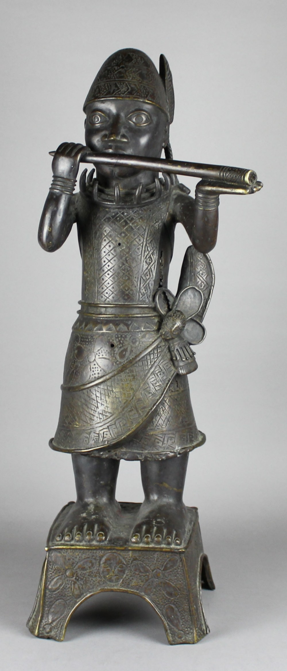 AN 18TH/19TH CENTURY BENIN DARK PATINATED BRONZE FIGURE OF A HORN-BLOWER, probably an altar