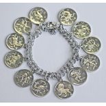 A STERLING CHARM BRACELET, the double curb-type links suspending various medallions depicting the