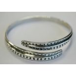 A DAVID ANDERSON (NORWAY) 925S STERLING BANGLE of circular cross-over form decorated with stylised