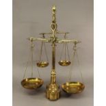 A SET OF DOUBLE BRASS BALANCE SCALES having fish-form beams, brackets and supports, reeded columns