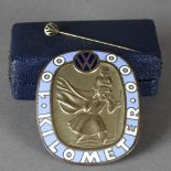 A 20TH CENTURY ENAMELLED BRONZED METAL VW 100,000 KILOMETER OVAL BADGE, with image of St Christopher