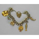 A GOLD AND YELLOW METAL CHARM BRACELET, the curb-type bracelet with heart-shaped padlock clasp (