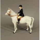 A BESWICK POTTERY HUNTSWOMAN on a dappled grey horse, model number 1730, 21cm(h) CONDITION: