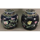A PAIR OF CHINESE FAMILLE ROSE POTTERY GINGER JARS AND COVERS, the dark blue ground enamelled in