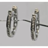 A PAIR OF 18CT WHITE GOLD AND DIAMOND EARRINGS of hinged horseshoe loop form, one side pressure-