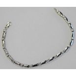 A 9CT WHITE GOLD AND DIAMOND BRACELET, plain oblong links interspersed by diamond brilliants