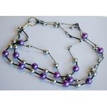 AN EMPORIO ARMANI FASHION NECKLACE, three strands of silver and purple coloured beads, marked with