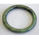A JADE BANGLE, mottled dark green colouring. 8cm(d) CONDITION: Good order.