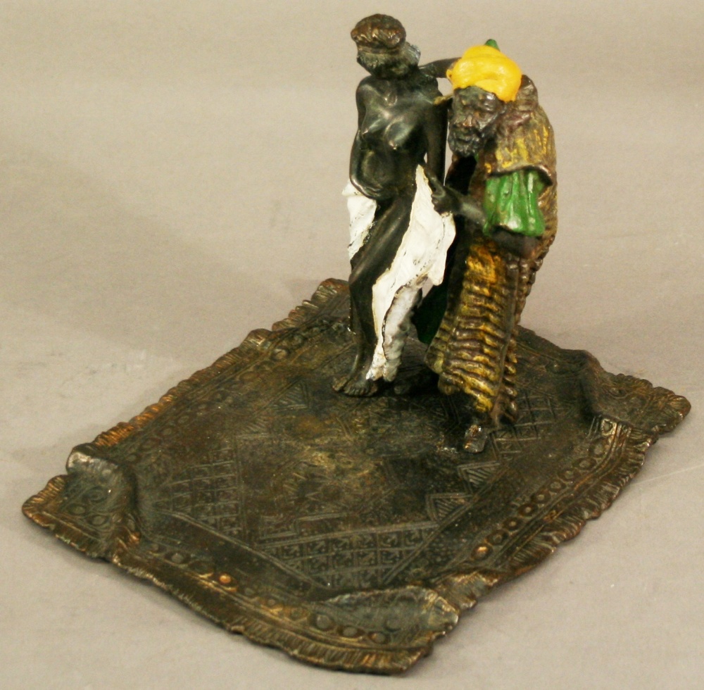 A COLD-PAINTED BRONZE 'SLAVE TRADER' GROUP modelled standing on a carpet, bearing 'Nam Greb' (