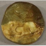 A CARVED HARDSTONE PENDANT PLAQUE of ovoid form, carved with a kylin and crane, partly translucent
