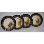 Four Royal Worcester plates signed Johnson, decorated with game birds within blue and gilt